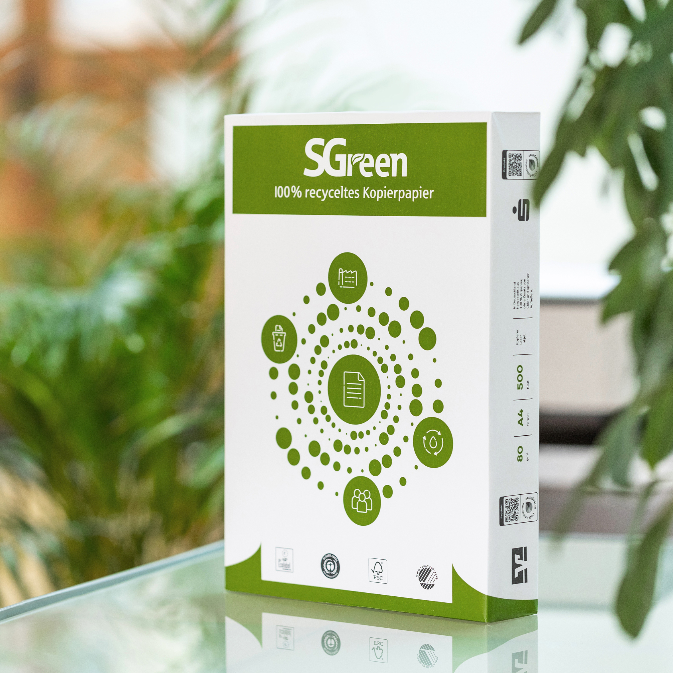 Kopierpapier SGreen Kopierpapier SGreen steht auf Glastisch zwischen Pflanzen